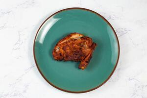 bbq chicken breast piece served in a dish isolated on background side view photo