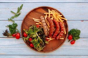 Traditional German Grilled sausages with tomatoes wooden pan on a wood table background. Top view photo