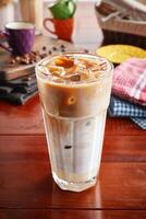 A jar of healthy fresh SPANISH ICED LATTE isolated on wooden background side view photo