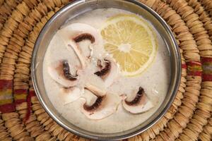 Mushroom Soup with lemon served in bowl isolated on background top view arabic style photo
