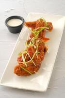 Chicken Buffalo Wings with dip served in a dish isolated on yellow background side view of fastfood photo