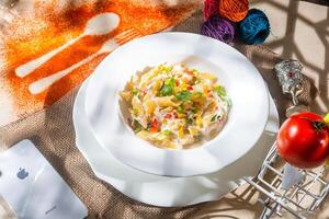 Tan cooked green pasta with tomato a plate isolated on background top view of italian fast food photo