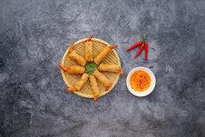 Fried Prawn Roll with sauce served in a dish isolated on dark grey background top view of japanese food photo