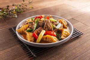 Farmhouse Spicy Duck Dumplings with tomato served dish isolated on wooden table top view of Hong Kong food photo