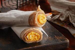 egg cheese chapati omelet roll served in a dish isolated on wooden background side view photo