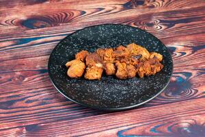 spicy bbq chicken tikka boti kabab served in a dish isolated on background top view photo