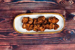 spicy bbq chicken tikka boti kabab served in a dish isolated on background top view photo
