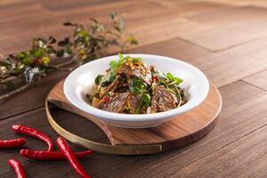 Spicy chilli Beef Show served dish isolated on wooden table top view of Hong Kong food photo