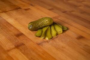 Gherkins cucumber pickled slice isolated on wooden table top view of indian food photo