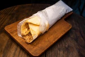 Arabic Chicken shawarma roll wrap isolated on wooden board top view arabic spicy fastfood photo