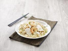 Braised Hor Fun with Seafood with chopsticks served in a dish isolated on mat side view on grey background photo