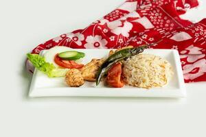 Turkish barbecues Sis Chicken Kebab with rice and salad in a dish isolated on colorful table cloth top view on grey background photo