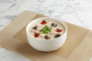 Century Egg with Minced Pork Congee served in a bowl isolated on mat side view on grey marble background photo