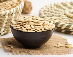 Egyption seed served in a bowl isolated on napkin side view of nuts on grey background photo