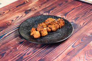 spicy bbq chicken tikka boti kabab served in a dish isolated on background top view photo