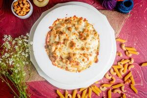 chicken cheese Cashew nuts pasta in a plate top view on wooden background photo