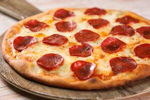 pepperoni pizza served in cutting board isolated on background top view of fast food photo