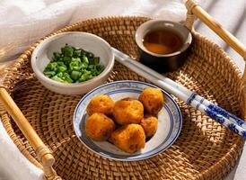 Traditional Hong Kong style fishball in a dish with spring onion, sauce and chopstick side view street food photo