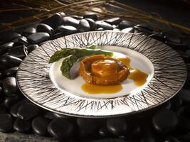 Braised Head Whole Australian Abalone in Brown Sauce served in dish isolated on side view of food photo