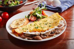 Sausage omelette roll with salad served in a dish isolated on wooden background side view photo