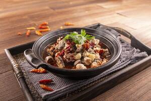 Chilli Spicy Frog Pot served dish isolated on wooden table top view of Hong Kong food photo