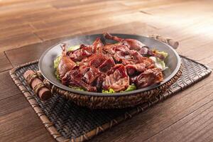 Spicy chilli Hunan style salted duck served dish isolated on wooden table top view of Hong Kong food photo