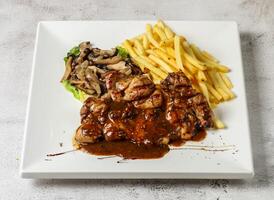 black pepper chicken with mushroom and french fries served in dish isolated grey background top view singapore fast food photo