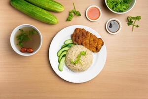 Chicken Cutlet Rice with raw cucumber, Coriander, salad, sauce and soup served in a dish isolated on wooden background top view photo