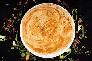 peshawari paratha servido en plato aislado en oscuro antecedentes parte superior ver de indio especias comida foto