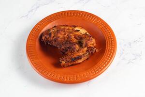 bbq chicken breast piece served in a dish isolated on background side view photo