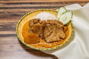 Pork chop curry with rice served in dish isolated on wooden table top view of hong kong fast food photo