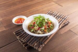 Spicy Wild Pepper Fresh Fish Skin served dish isolated on wooden table top view of Hong Kong food photo