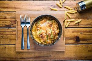 Baked Chicken Pasta isolated on wooden board top view on table fastfood photo