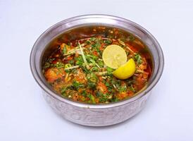 chicken boneless handi with lemon slice served in dish isolated on grey background top view of pakistani food photo