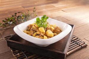 Braised Chicken with Sour Radish served dish isolated on wooden table top view of Hong Kong food photo