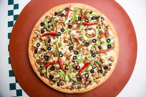 Chicken Fajita Pizza isolated on wooden background, spiced chicken cubes and cheese combination on bread, Italian food top view photo