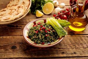 TABBOULEH with bread and lime served in a dish isolated on grey background side view photo