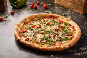 Veggie Pizza topping with cherry tomato, mushroom, capsicum and coriander isolated on dark background with raw food top view of italian fastfood appetizer photo