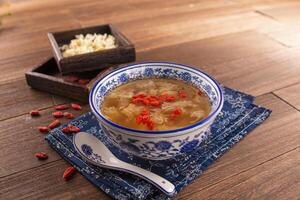 Thawed Spicy Frozen Sweet Soup Red Dates, Snow Fungus and Lotus Seeds served dish isolated on wooden table top view of Hong Kong food photo