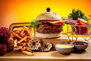 Beef Cheese burger with french fries, potato and tomato slice isolated on wooden board slide view on table fast food photo