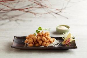 Crispy Chicken Cartilage tossed with Salt and Pepper with mayo dip sauce served in a dish isolated on grey background photo