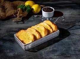 Cheese garlic bread in a deep fryer dish top view on dark background a morning meal photo