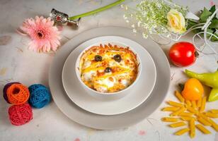 Fiery BBQ chicken Pasta with raw tomato in a bowl isolated on background side view photo