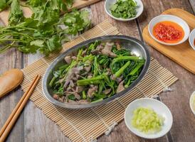 Pork Meat with Mix vegetables with chilli sauce, noodles, spoon and chopsticks served in dish isolated on napkin top view of hong kong food photo