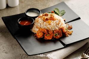 Shrimp Biryani with raita and sauce served in a dish isolated on grey background side view fast food photo