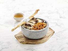 Assorted Mushrooms Cordyceps Flower Soup served in Japanese Stone Pot Served in a bowl isolated on wooden board side view on grey background photo