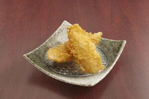 deep fried Fish Tempura served in a dish isolated on wooden table background side view of singapore food photo