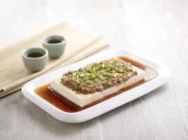 Steamed Spring Water Tofu with Minced Pork and Salted Fish with chopsticks served in a dish isolated on mat side view on grey background photo