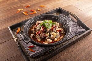 Chilli Spicy Frog Pot served dish isolated on wooden table top view of Hong Kong food photo