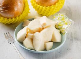 Freshly cut premium pears with raw fruits cut served in disposable glass isolated on background top view taiwan food photo